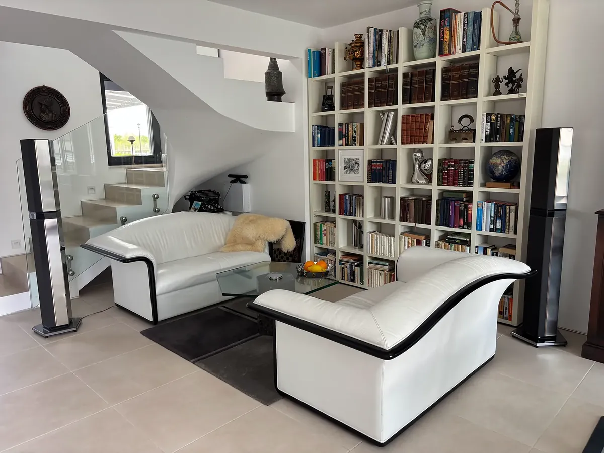 Living room with white sofas and bookcase wall, villa in the Victoria Sunrise quarter, Victoria development near Pomorie