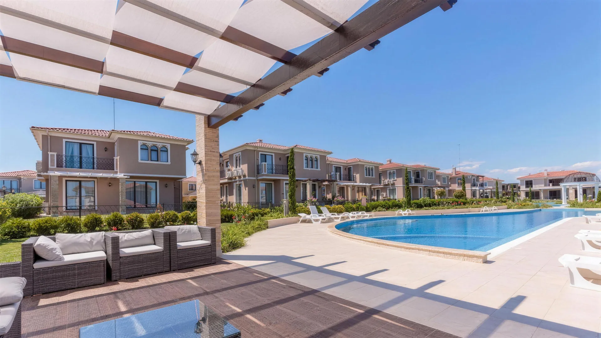 Lounge area under the pergola by the pool