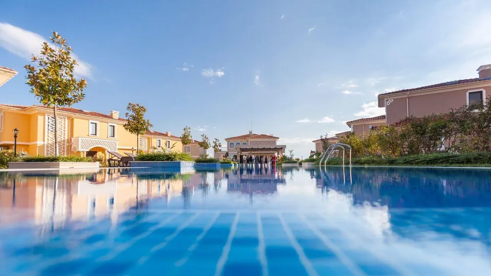 Pool reflecting the villas in the evening light