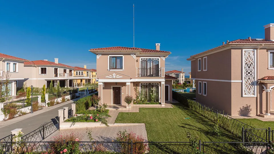 Villa with a balcony and front garden on a street in the development