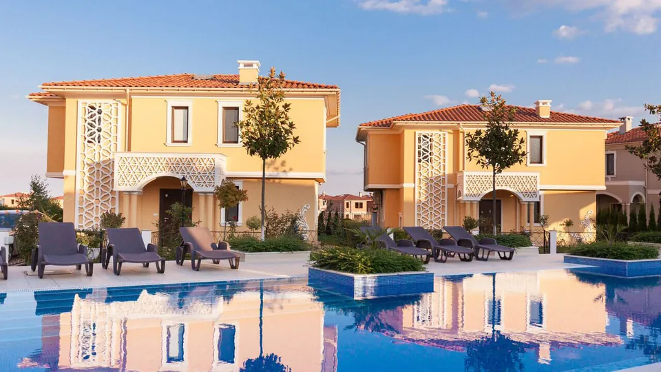 Yellow villas reflected in the development's pool